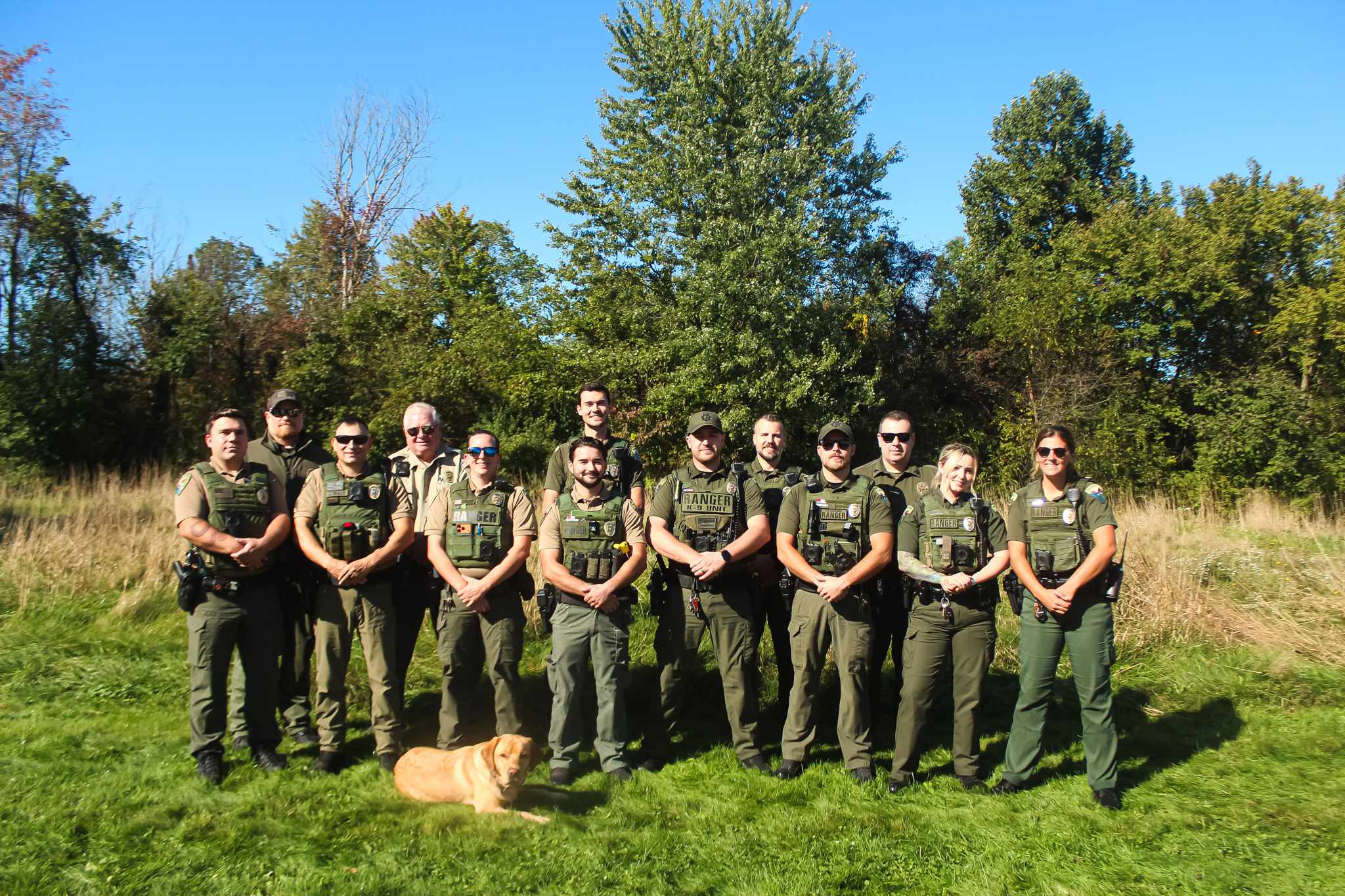 Group of Park Rangers in a row with dog in front
